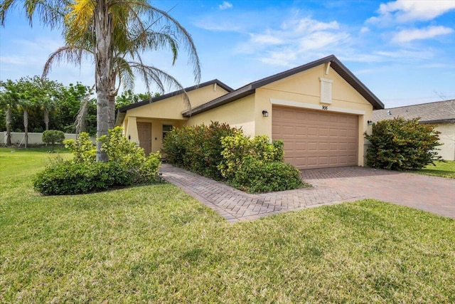 view of front of house with stucco siding, decorative driveway, a garage, and a front lawn