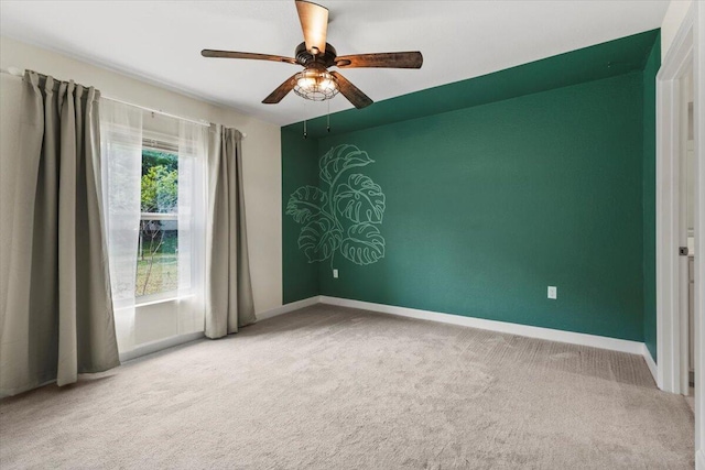 unfurnished room with carpet, a ceiling fan, and baseboards