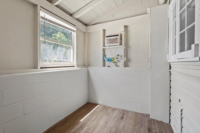 interior space with vaulted ceiling with beams, wood finished floors, a wall mounted AC, and wooden ceiling