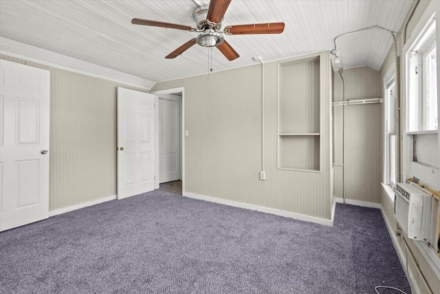 unfurnished bedroom featuring carpet, a closet, baseboards, a wall mounted AC, and ceiling fan