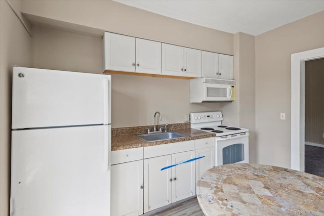 kitchen with white cabinets, a sink, and white appliances