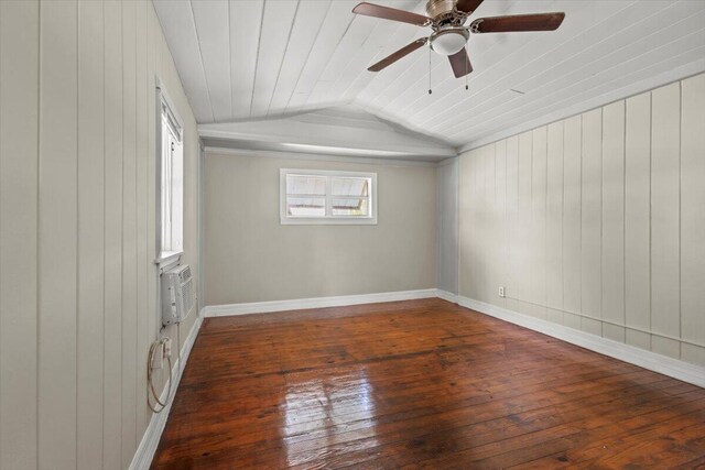 unfurnished room featuring hardwood / wood-style floors, wooden walls, ceiling fan, baseboards, and lofted ceiling