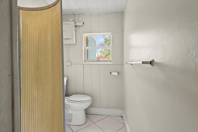 bathroom with tile patterned floors, baseboards, and toilet