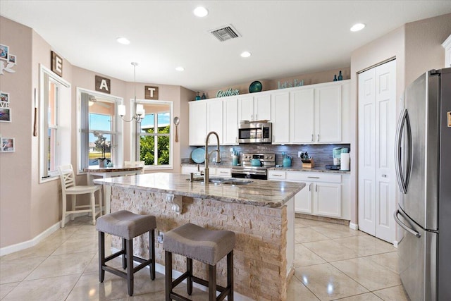 1018 NW Demedici Rd, Port Saint Lucie, FL 34986 - kitchen with appliances with stainless steel finishes, a sink, backsplash, light tile patterned flooring, and light stone counters
