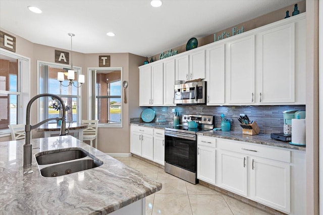 1018 NW Demedici Rd, Port Saint Lucie, FL 34986 - kitchen featuring appliances with stainless steel finishes, a sink, tasteful backsplash, healthy amount of natural light, and recessed lighting