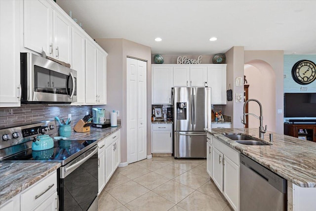 1018 NW Demedici Rd, Port Saint Lucie, FL 34986 - kitchen with stainless steel appliances, a sink, decorative backsplash, white cabinets, and light stone counters