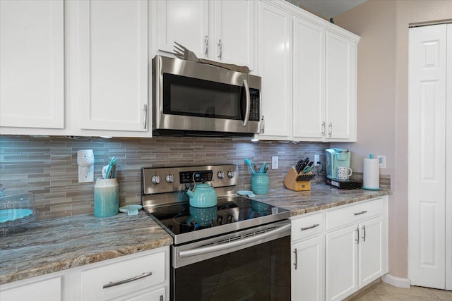1018 NW Demedici Rd, Port Saint Lucie, FL 34986 - kitchen with stainless steel appliances, light stone countertops, white cabinets, and backsplash
