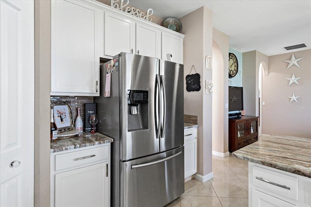 1018 NW Demedici Rd, Port Saint Lucie, FL 34986 - kitchen with stainless steel refrigerator with ice dispenser, arched walkways, stone counters, white cabinets, and tasteful backsplash