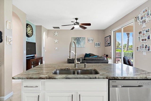 1018 NW Demedici Rd, Port Saint Lucie, FL 34986 - kitchen featuring dishwasher, a sink, arched walkways, open floor plan, and light stone countertops
