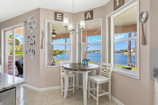 1018 NW Demedici Rd, Port Saint Lucie, FL 34986 - dining room featuring a water view, baseboards, light tile patterned floors, and a ceiling fan