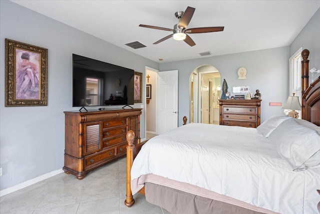 1018 NW Demedici Rd, Port Saint Lucie, FL 34986 - bedroom with baseboards, arched walkways, ceiling fan, ensuite bathroom, and light tile patterned floors