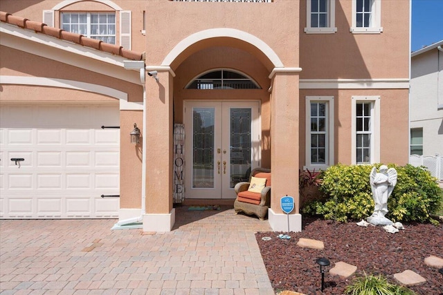 1018 NW Demedici Rd, Port Saint Lucie, FL 34986 - doorway to property featuring french doors, stucco siding, and a garage