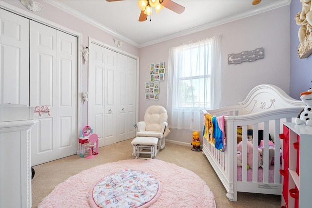1018 NW Demedici Rd, Port Saint Lucie, FL 34986 - carpeted bedroom featuring a crib, crown molding, multiple closets, ceiling fan, and baseboards