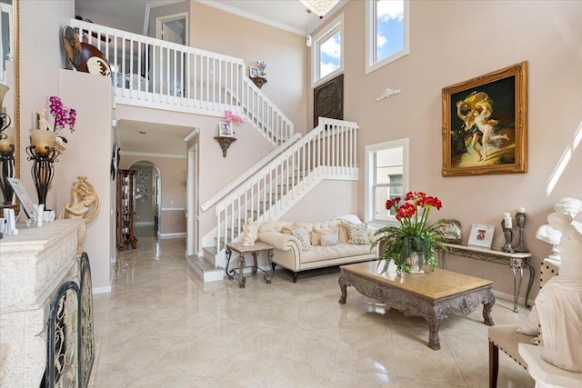 1018 NW Demedici Rd, Port Saint Lucie, FL 34986 - living room featuring crown molding, arched walkways, a towering ceiling, stairway, and baseboards