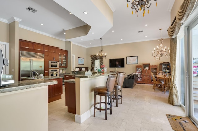 2409 NE 12th St, Fort Lauderdale, FL 33304 - kitchen with built in fridge, a kitchen bar, a large island with sink, and an inviting chandelier