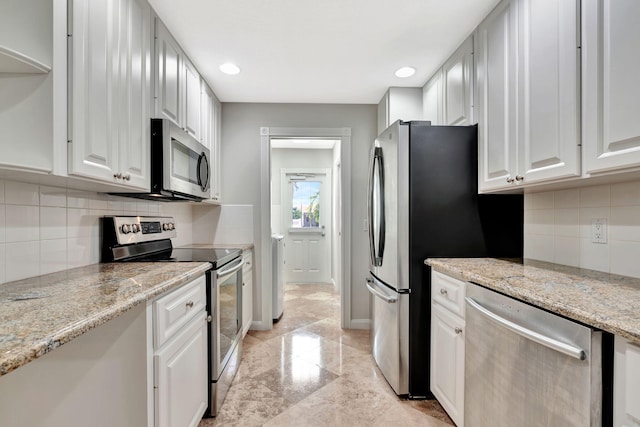 3216 W Community Dr, Jupiter, FL 33458 - kitchen featuring stainless steel appliances, tasteful backsplash, white cabinets, light stone countertops, and light marble finish floors