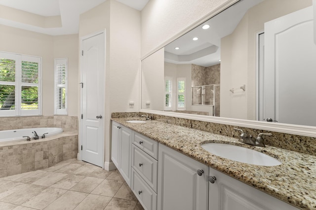 bathroom featuring a shower stall, a bath, a sink, and double vanity