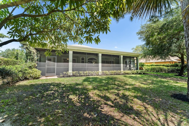 rear view of property with a yard and a sunroom