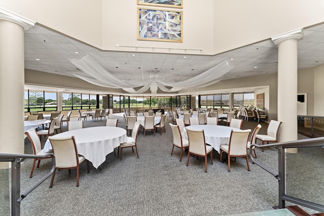 dining space with decorative columns, carpet floors, recessed lighting, and a drop ceiling
