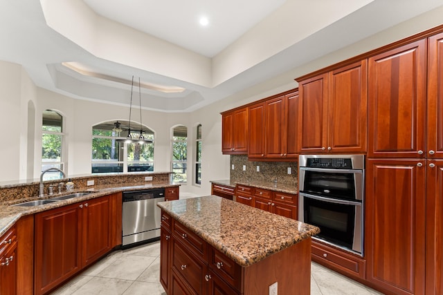 kitchen featuring a sink, arched walkways, dark stone counters, decorative backsplash, and appliances with stainless steel finishes