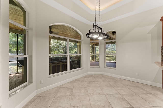 unfurnished dining area with a ceiling fan, baseboards, tile patterned flooring, and a healthy amount of sunlight