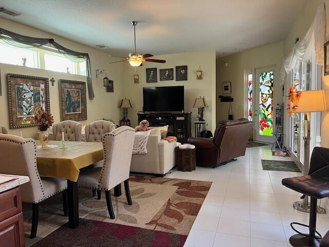 dining room with a ceiling fan, visible vents, and light tile patterned floors