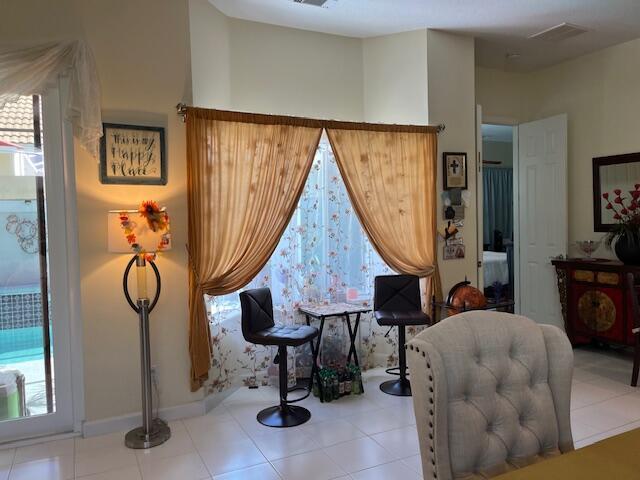 sitting room featuring visible vents, tile patterned flooring, and baseboards