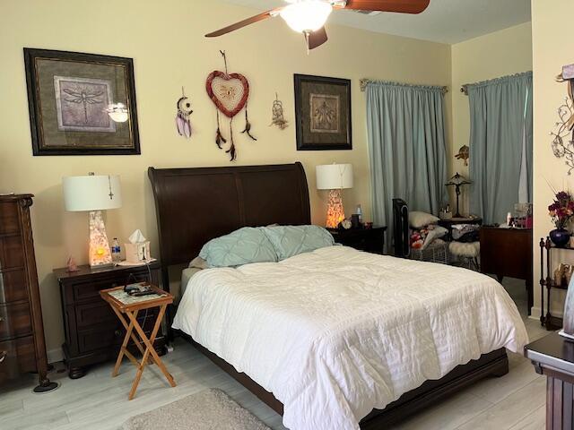 bedroom with light wood-type flooring and ceiling fan