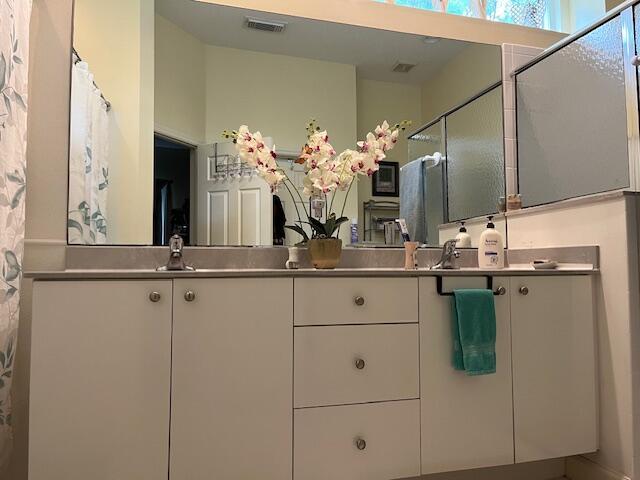 bathroom featuring double vanity, visible vents, and curtained shower