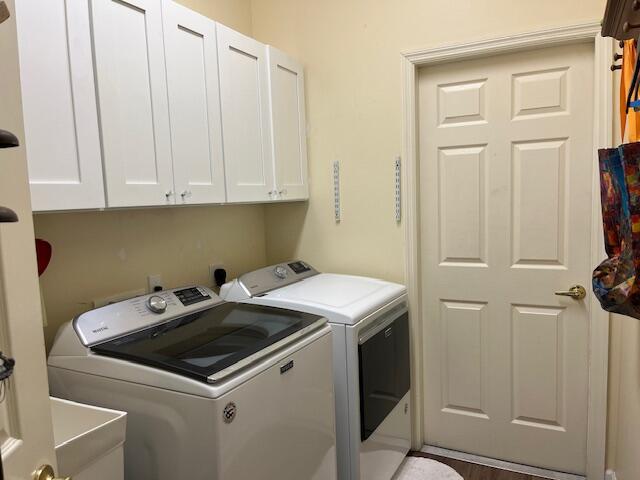 laundry room featuring washer and dryer, cabinet space, and a sink