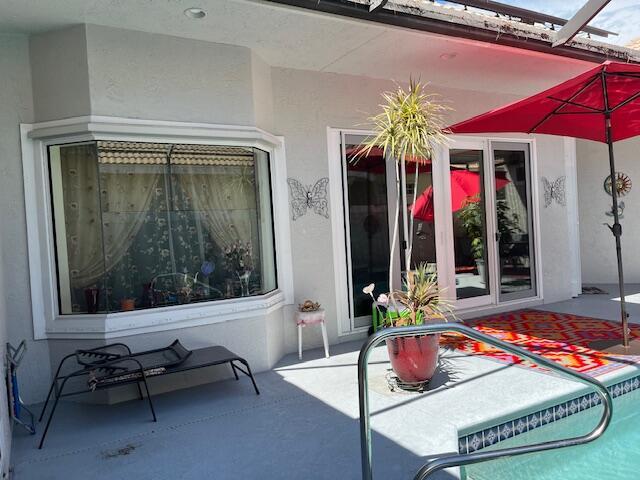 exterior space with an outdoor pool, a patio, and stucco siding