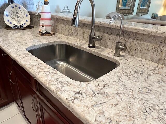 interior details featuring a sink and light stone counters
