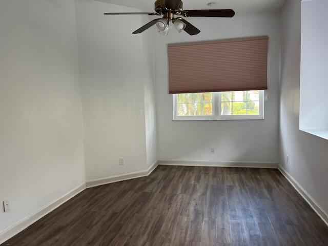 empty room featuring ceiling fan, wood finished floors, and baseboards