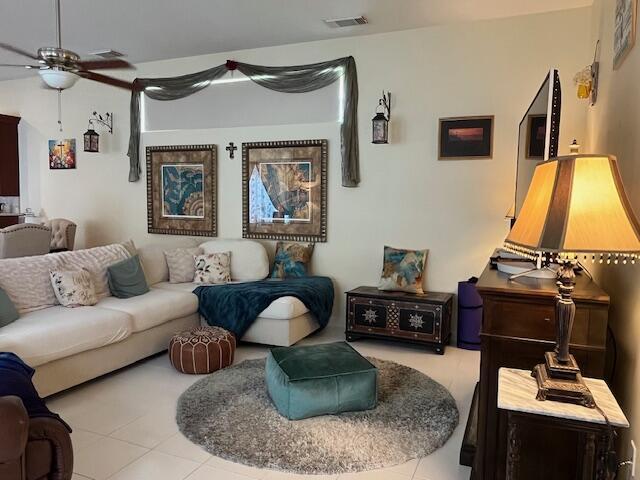 living room featuring visible vents, a ceiling fan, and tile patterned flooring