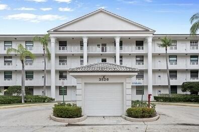 3526 Whitehall Dr Unit 106, West Palm Beach, FL 33401 - view of property featuring concrete driveway and an attached garage
