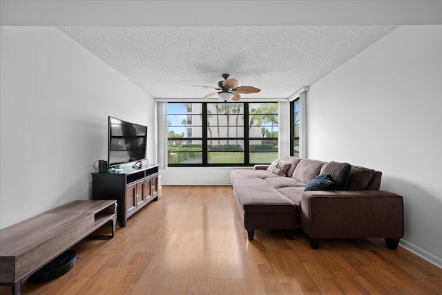 3526 Whitehall Dr Unit 106, West Palm Beach, FL 33401 - living room with light wood-style flooring, a textured ceiling, a ceiling fan, and baseboards