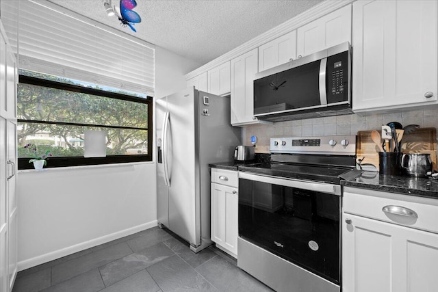 3526 Whitehall Dr Unit 106, West Palm Beach, FL 33401 - kitchen with appliances with stainless steel finishes, white cabinets, backsplash, baseboards, and a textured ceiling