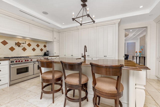 2500 S Ocean Blvd Unit Ph2, Boca Raton, FL 33432 - kitchen featuring range with two ovens, backsplash, a kitchen breakfast bar, recessed lighting, and a raised ceiling