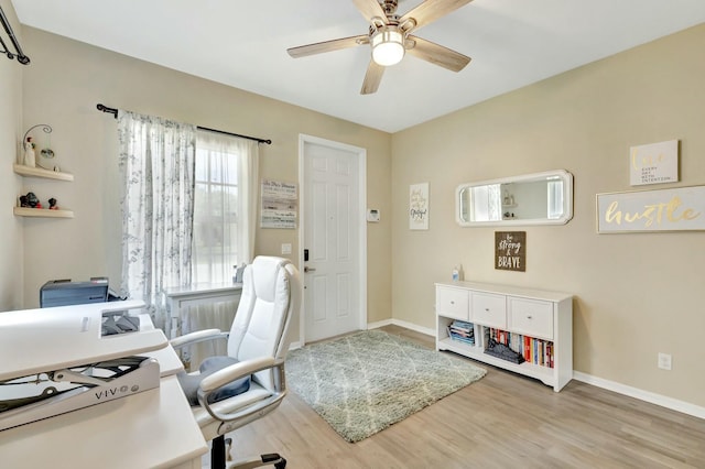 home office featuring baseboards, a ceiling fan, and wood finished floors