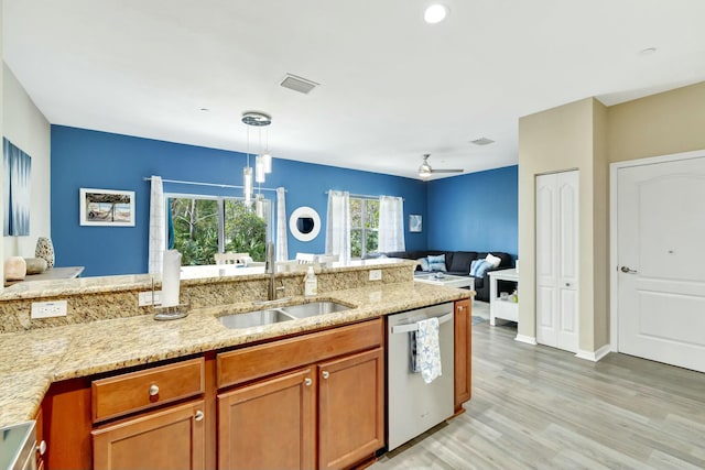 kitchen featuring stainless steel dishwasher, light stone countertops, brown cabinets, a sink, and light wood-style flooring