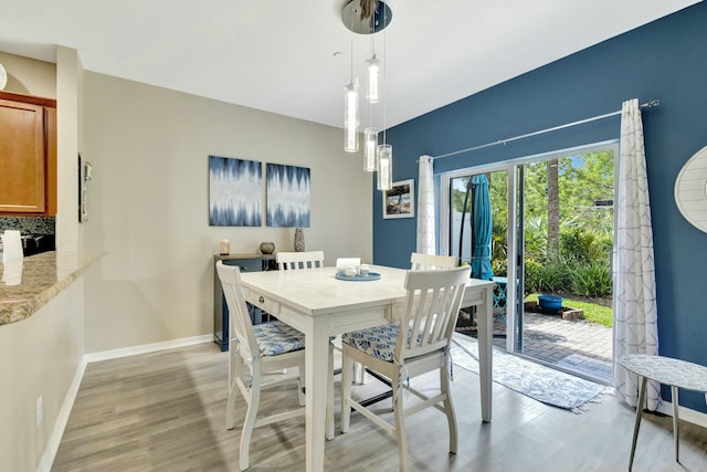dining room featuring baseboards and light wood finished floors