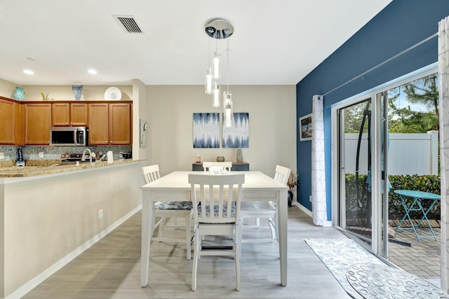 dining room featuring light wood-style floors, baseboards, recessed lighting, and visible vents