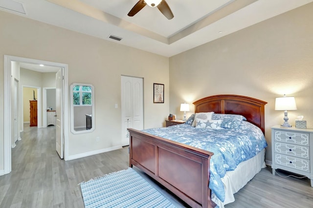 bedroom featuring baseboards, a ceiling fan, a closet, and light wood-style flooring