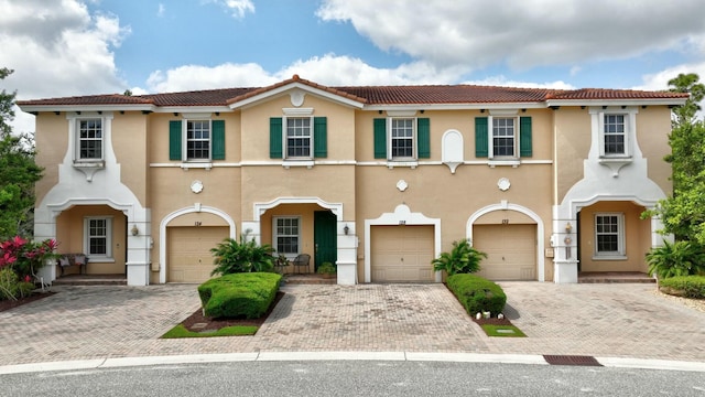 view of front of home featuring a garage, stucco siding, driveway, and a tiled roof