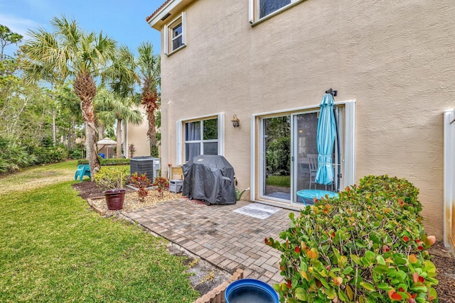 back of house featuring stucco siding, a yard, a patio area, and cooling unit