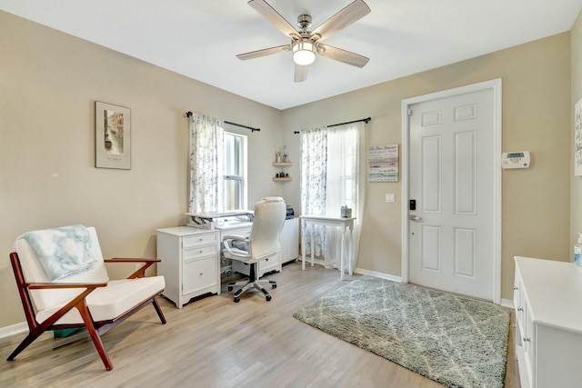 home office featuring a ceiling fan, baseboards, and light wood-type flooring