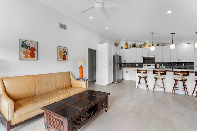 living area with recessed lighting, lofted ceiling, visible vents, and a ceiling fan