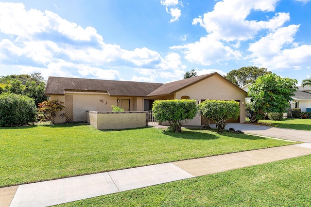 ranch-style house featuring a front lawn, a fenced front yard, concrete driveway, an attached garage, and stucco siding
