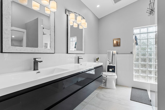 bathroom featuring a sink, tile walls, double vanity, toilet, and recessed lighting