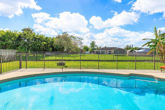view of swimming pool with a yard, a fenced in pool, a patio area, and fence